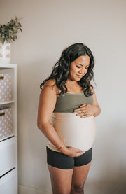 expectant mother standing holding belly